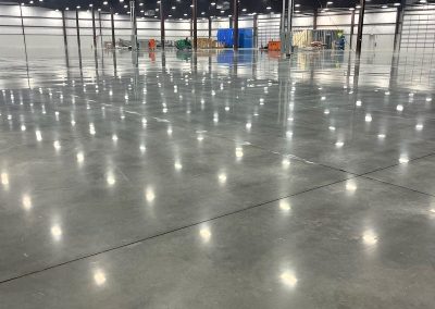 Empty warehouse with shiny concrete floor.